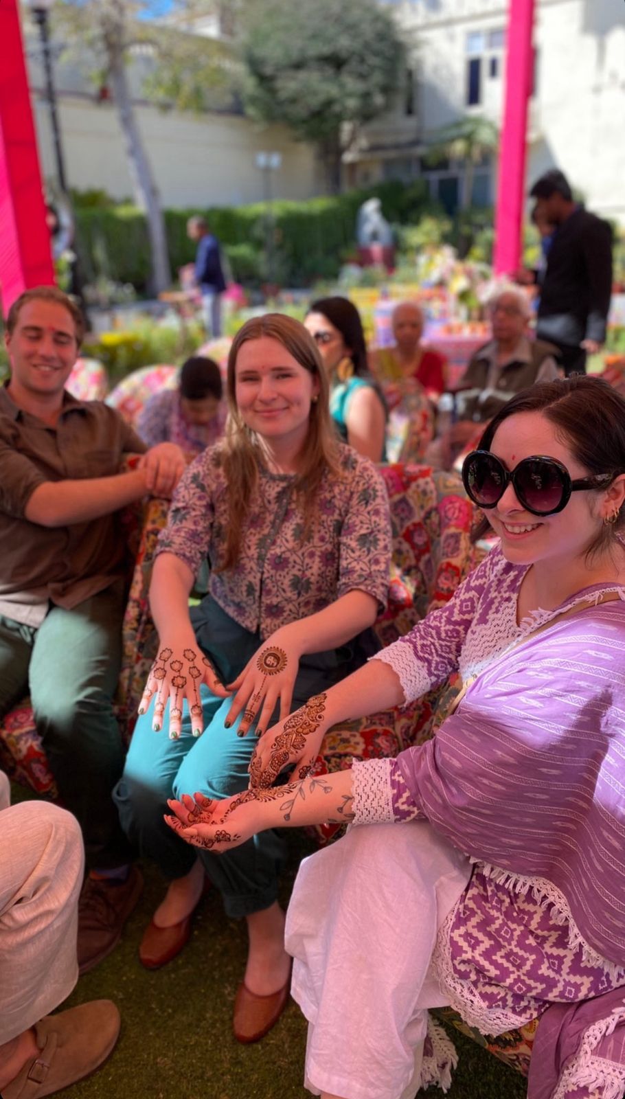 Wedding guests showing off their finished henna designs